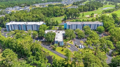 Aerial view of property and surrounding area with a local golf course and a large body of water