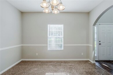 Carpeted foyer entrance with arched walkways, a ch