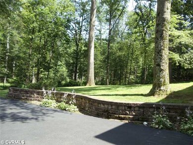 Exterior Front - Parking area with stone wall