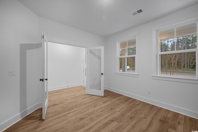 Unfurnished bedroom featuring visible vents, baseb