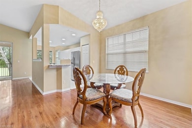 Dining space with a chandelier, light wood-style flooring, and baseboards