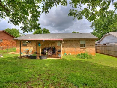Rear view of property with brick siding, a patio, and a fenced backyard