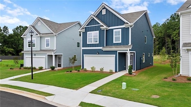 View of front facade featuring board and batten siding, a front lawn, and a garage
