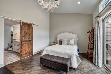 Bedroom featuring wood finished floors, a barn doo