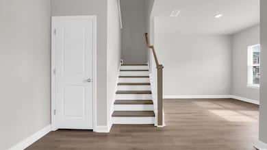 Stairs featuring wood finished floors and recessed lighting