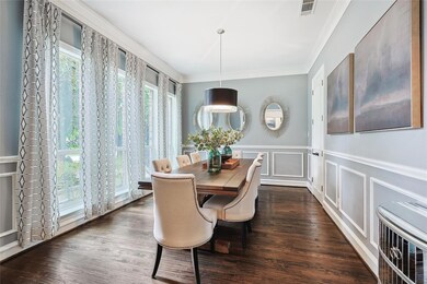 Dining room with ornamental molding, plenty of natural light, and wood floors.