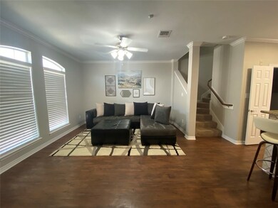 Living room featuring ceiling fan, crown molding,