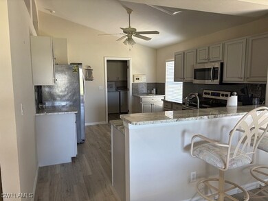 Kitchen featuring ceiling fan, a peninsula, vaulte
