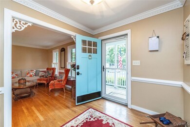 Foyer with crown molding and light hardwood / wood