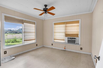 Empty room featuring baseboards, ceiling fan, orn