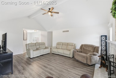 Living room featuring beam ceiling, light wood finished floors, a ceiling fan, and high vaulted ceiling