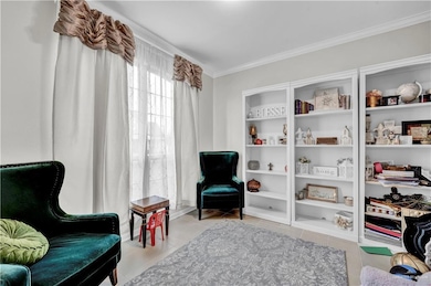 Sitting room featuring crown molding and tile patterned floors