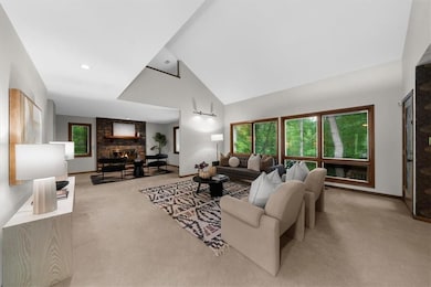 Living area with carpet flooring, a large fireplac