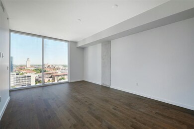 Empty room with a city view, dark wood-style floo