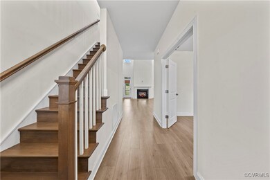 Staircase with wood finished floors, a lit firepla