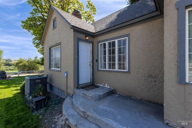 Doorway to property with stucco siding, roof with shingles, and a chimney