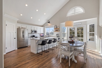 Dining area featuring high vaulted ceiling, recessed lighting, healthy amount of natural light, dark wood-type flooring, and french doors