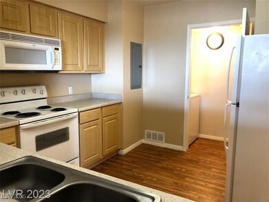 Kitchen featuring white appliances, dark wood-type