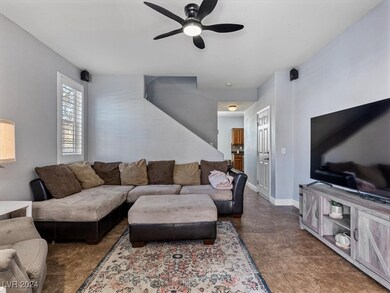 Living room with tile floors, shutters, ceiling fa