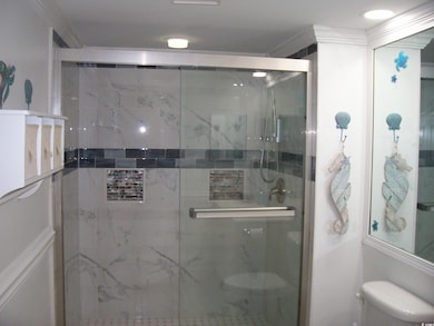 Bathroom featuring toilet and a stall shower
