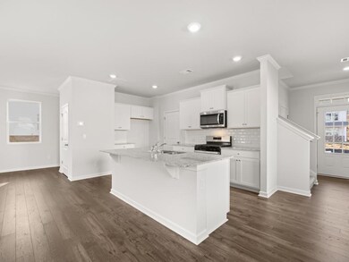 Elston kitchen with granite countertops and a white subway tile backsplash and white shaker cabinets
