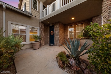 Exterior entry at dusk featuring a balcony, brick