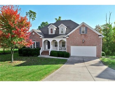 Welcome - Double-width concrete driveway, walkway from the driveway to the covered 5 x 42 brick and aggregate 6 x 18 covered front porch with wooden columns, porch light fixture and power outlet, entrance door with sidelight and transom windows