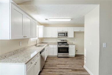Kitchen with stainless steel appliances, white cab
