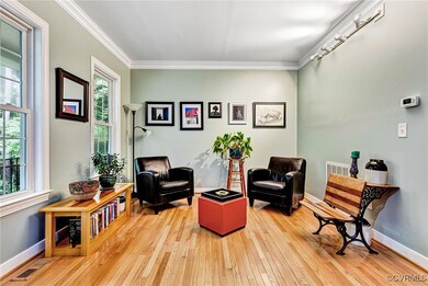 Living area with ornamental molding and hardwood / wood-style flooring