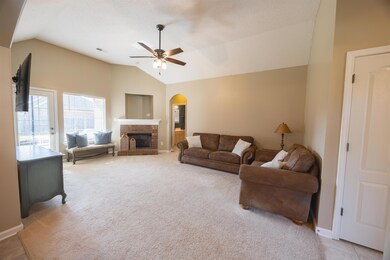 Living room featuring light colored carpet, a fire