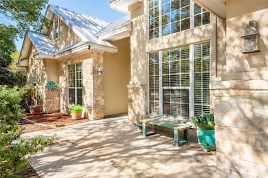 Property entrance featuring stone siding, a metal roof, and stucco siding