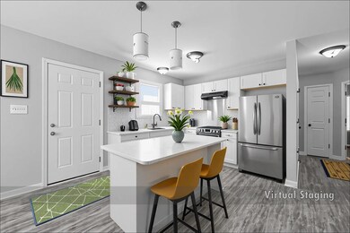 Kitchen with white cabinetry, stainless steel appliances, decorative light fixtures, decorative backsplash, and a kitchen bar