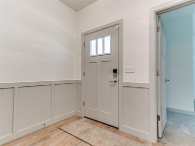 Foyer entrance with light wood-style floors, a dec