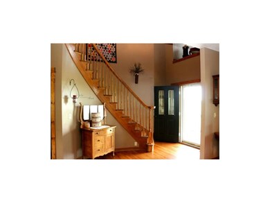Gorgeous Entry with Curved Grand Staircase, Oak Steps, Display Area above Front Door, Open to Formal Dining Room and Great Room, Door to Lower Level