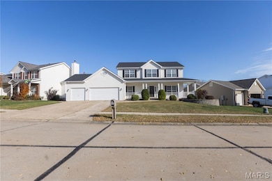 View of front of property featuring covered porch, concrete driveway, a front yard, and an attached garage