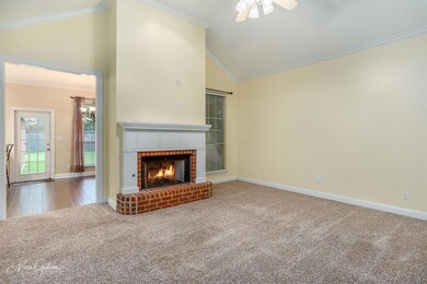 Living room with a fireplace, ceiling fan, carpet 
