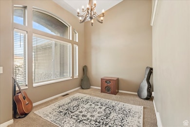 Foyer entrance featuring carpet and a chandelier