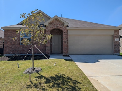 View of front of house featuring driveway, a front lawn, an attached garage, brick siding, and roof with shingles