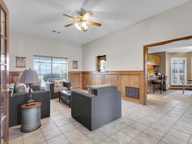 Living room with light tile patterned floors and ceiling fan