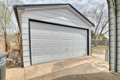 Detached garage featuring fence and a gate