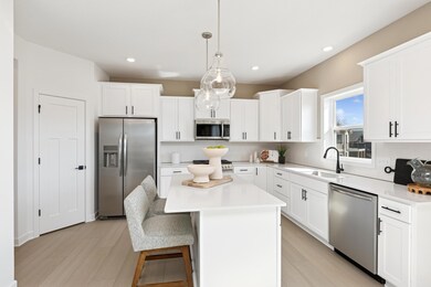 (Photos of model home, finishes will vary) The spacious kitchen features brand-new stainless steel appliances, a center island and ample cabinetry storage.