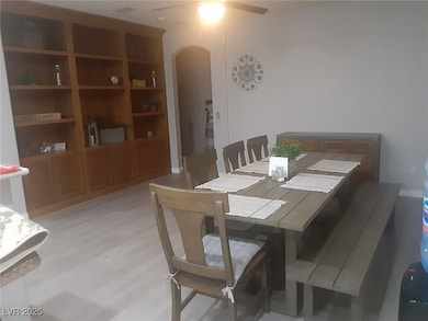 Dining space with arched walkways, ceiling fan, an
