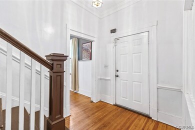 Foyer featuring ornamental molding and light hardw