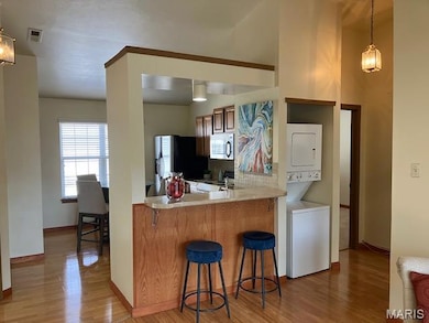 Kitchen featuring hanging light fixtures, a kitchen breakfast bar, and plenty of natural light