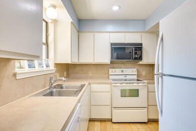 Kitchen featuring white appliances, a sink, light