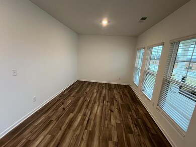 Spare room featuring dark wood-style flooring and baseboards