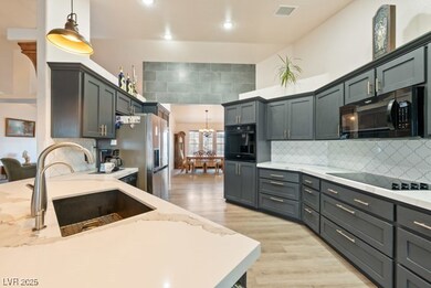 Kitchen with black appliances, a sink, light wood-