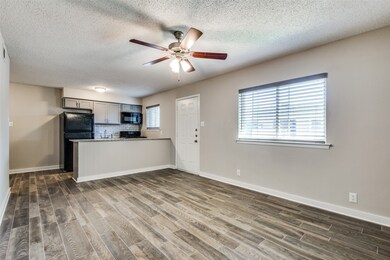 Unfurnished living room featuring dark wood-style floors, a textured ceiling, and ceiling fan