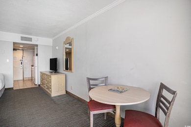 Carpeted dining space featuring baseboards, crown 