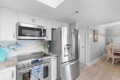 Kitchen with stainless steel appliances, white cab